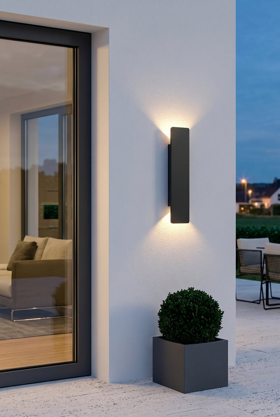 AI Studio Photo - Standing facing the camera, natural confident posture, arms relaxed at sides, front view, full body visible. CAMERA SHOT: Medium shot focusing on the wall lamp mounted on a white exterior wall, showcasing its design and the light it casts. [Full body]