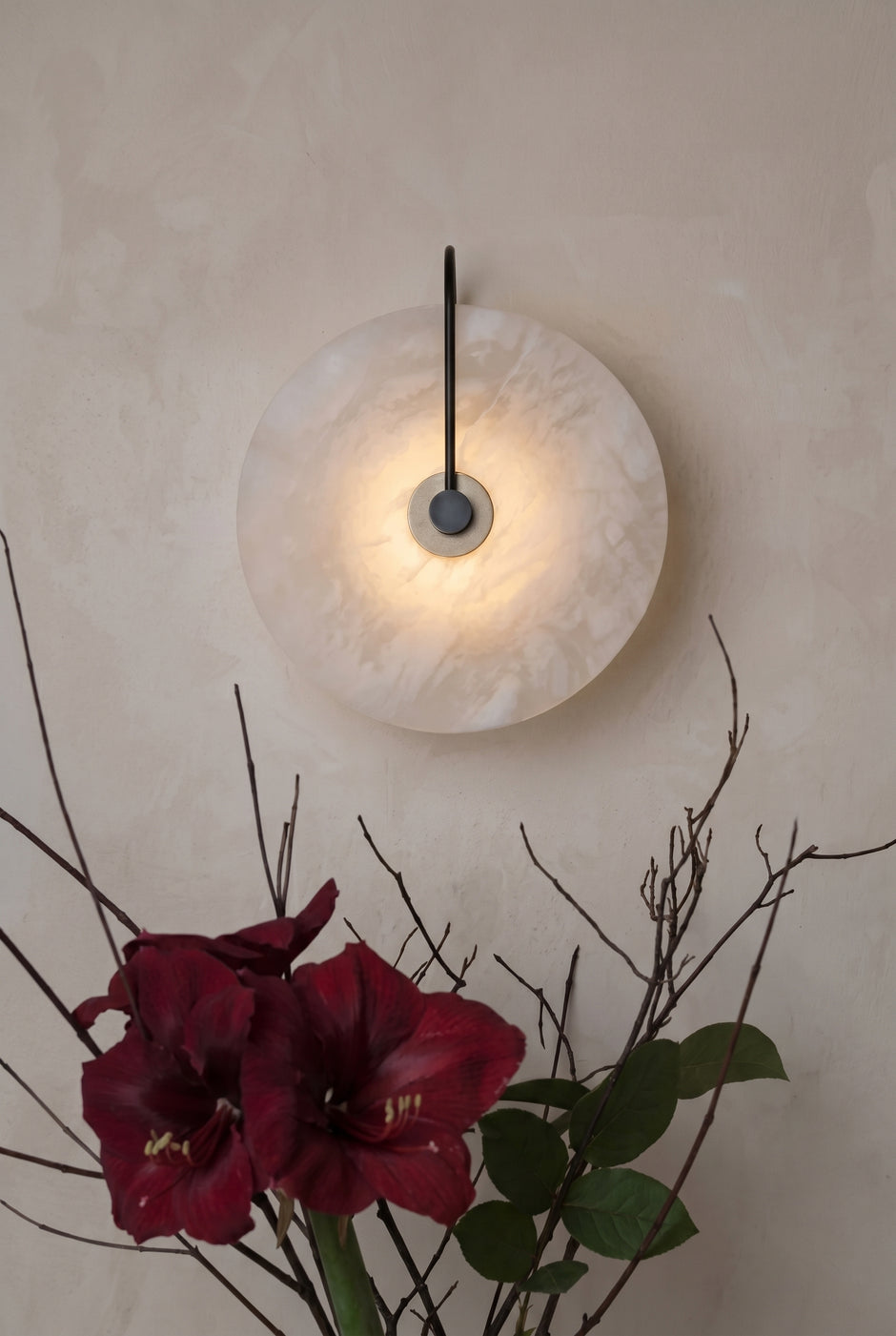 AI Studio Photo - Standing facing the camera, natural confident posture, arms relaxed at sides, front view, full body visible. CAMERA SHOT: Medium shot focusing on the wall sconce and its immediate surroundings, showcasing the texture of the alabaster and the interplay of light and shadow. [Full body]