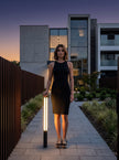 AI Studio Photo - Standing facing the camera, natural confident posture, arms relaxed at sides, front view, full body visible. CAMERA SHOT: A medium shot focusing on the lower half of the light column, showcasing its base and the illuminated panel extending upwards, with a hint of the surrounding environment. [Full body]